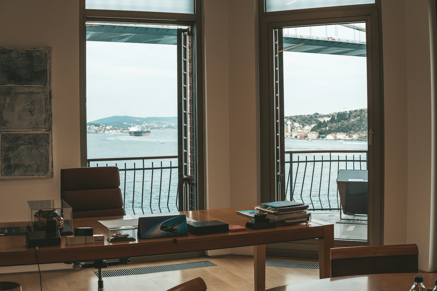Modern office desk overlooking a harbor with a cargo ship.