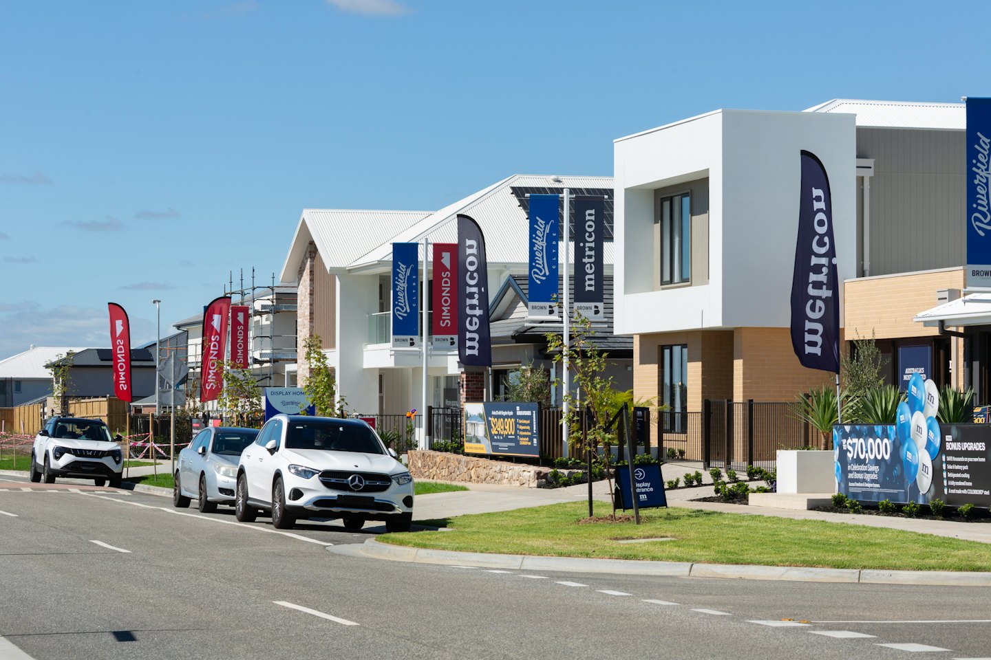 New modern houses for sale with builder flags and signs.